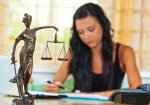 Scales of Justice Statue as female lawyer advocates against Tort Reform